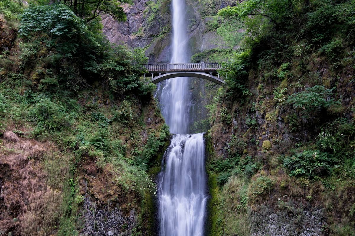 Multnomah Falls plunging in two tiers beneath the Benson Bridge in the Columbia River Gorge, Oregon.